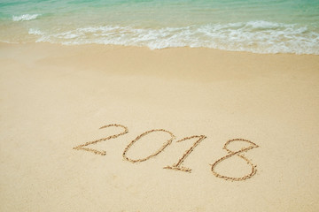 New Year 2018 is coming 2018 on a beach sand, the wave