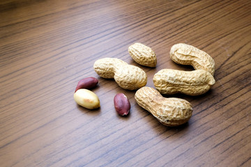 Peanuts, isolated on a wood background.