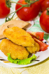 tray of croquettes filled with meat accompanied by tomato and wooden cutlery.