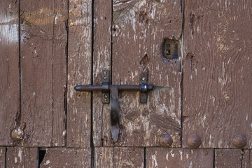 Closeup vintage door lock of external antique wooden door weathered on a Country house