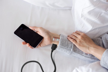 Overuse and tired Android Robot woman or Future human lay on bed with Low battery and charge via...