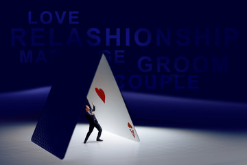 Funny concept of Man afraid of love or marriage, Present by Ace Heart Card on table and mini figure of male in Photo manipulation effect