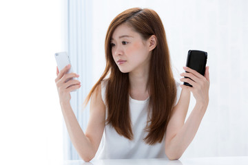 スマートフォンを比較する女性
