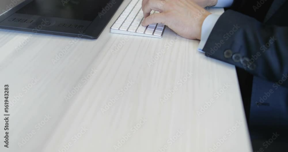 Poster closeup of businessman working on computer typing keyboard at office desk in creative space with cow