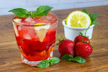 Glass of cold tea with mint,strawberry,lemon, on table
