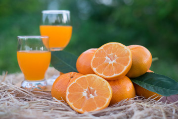 Orange juice and Orange fruits on wooden box and straw on blur green bokeh background. Vitamin C, iron, phosphorus, help the body to excrete well.