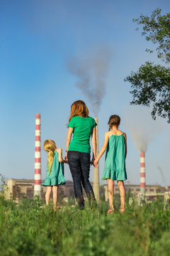 mother and daughter looking at the plant chimney-stacks