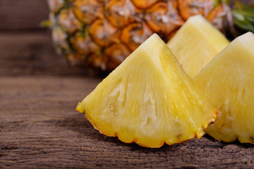 portion cut ripe pineapple on wooden table