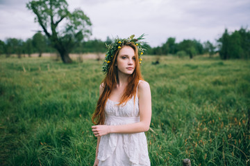 Beautiful young woman with wreath of wildflowers in their hair.