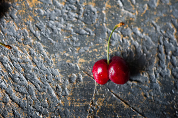 Ripe juicy cherry and cherry on a dark gilded background in a plate. Vitamins, greens, vegetarianism, healthy food, sports.