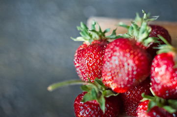 Ripe juicy strawberries on a dark gilded background in a plate. Vitamins, greens, vegetarianism, healthy food, sports.