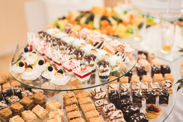 Delicious sweets on wedding candy buffet with desserts, cupcakes
