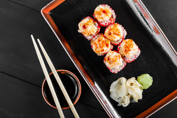 Sushi Roll - Maki Sushi with red caviar, Crab meat, avocado, cucumber and cream cheese on dark wooden background. Top view. Japanese cuisine