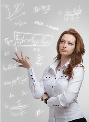 Woman scientist or student working with various high school maths and science formula.