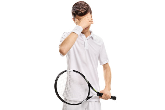 Teenage tennis player holding his head in disbelief