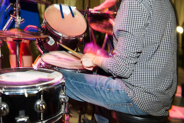 Musician plays drums in a rock band