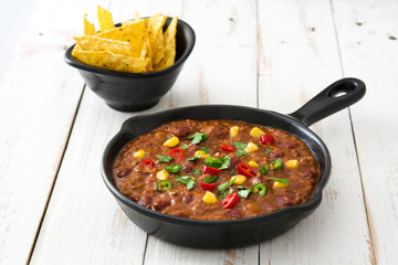 Traditional mexican tex mex chili con carne in a frying pan on white wooden table
