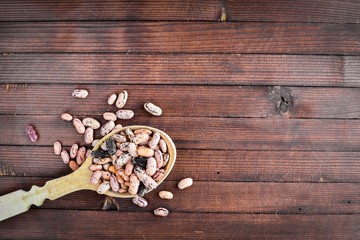 kidney beans. Wooden spoon. On Wooden background. Top view.