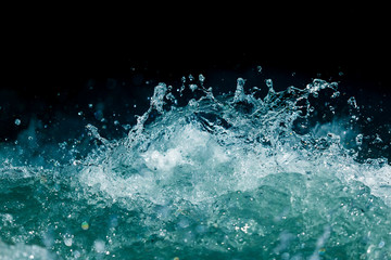 Spritzer von stürmischem Wasser im Ozean auf schwarzem Hintergrund