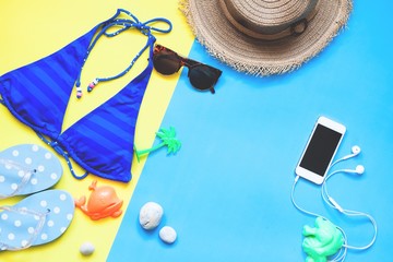 Flat lay of woman swimwear and accessories with smartphone, Summer concept