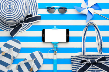 Beach accessories and smartphone on white and blue background. Top view, flat lay.
