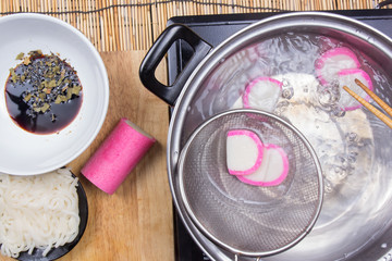 Chef boiling kamaboko (fish cake) in pot