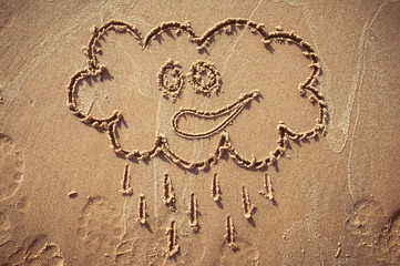 A speech cloud or think bubble drawn out on a sandy beach. Beach background. Top view