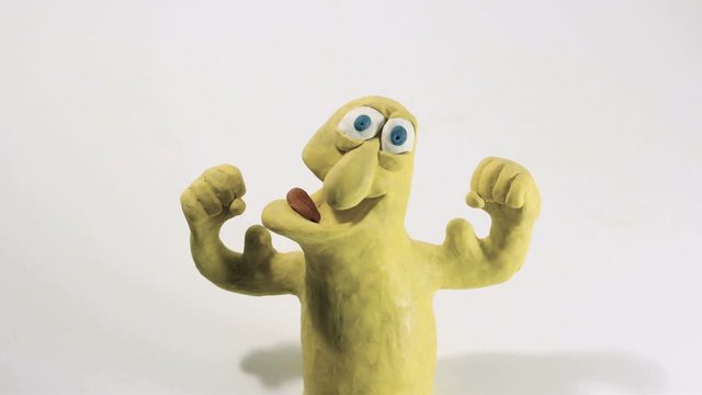 stop motion animation of a funny yellow plasticine character flexing his biceps. 