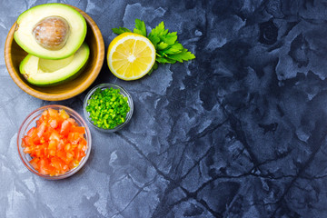 Raw ingredients for salad, salsa, guacamole - tomatoes, lemon, scallions, parsley, avocado. 