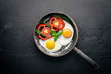 Fried egg with herbs and vegetables in a frying pan. Top view. Free space.