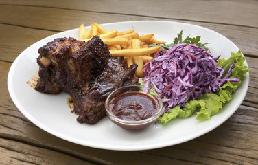 Delicious barbecued ribs seasoned with a spicy basting sauce and served with chopped fresh...