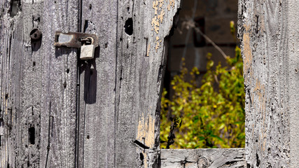 Vorhängeschloss an einem kaputtem Holztor