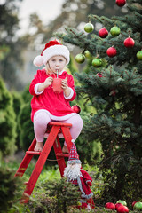 Little girl waiting for a Christmas in the wood. Christmas in juli.