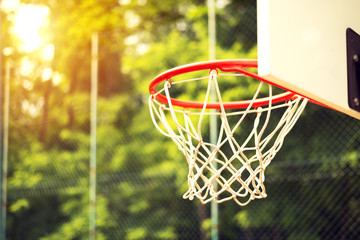 Junior basketball hoop in park surrounded by wire fence