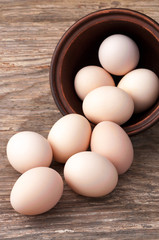 uncooked brown hen eggs on wooden table close-up