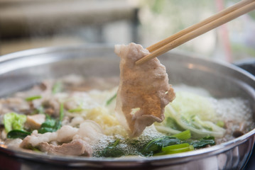 Shabu Shabu or Sukiyaki or hot pot  ,Hand holding pork using chopsticks, Japanese food in restaurant . - 161966648