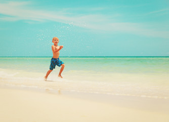 little boy run play with waves on beach