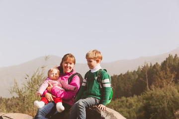 Fototapeta na wymiar mother with two kids hiking in mountains