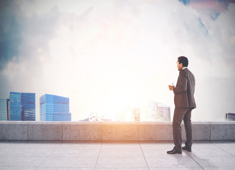 African American man on a roof looking at a city