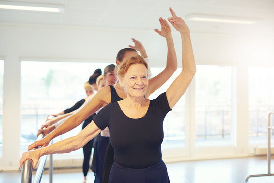 Smiling aged woman dancing ballet in group © Flamingo Images
