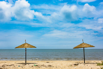 여름  해안가에 있는 파라솔과 하얀 구름