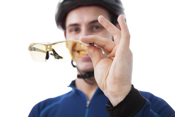 the cyclist holds the sports glasses