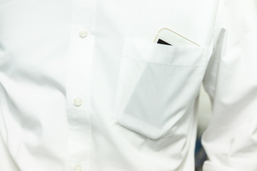 Smart phone in white shirt pocket of a business man