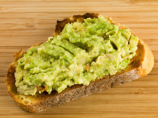 Mashed Avocado Pear On a Slice of Corn Bread