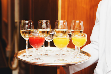 Waiter carrying tray with drinks on some festive event, party or wedding reception