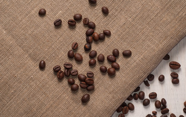 coffee beans on wooden background and rough cloth,