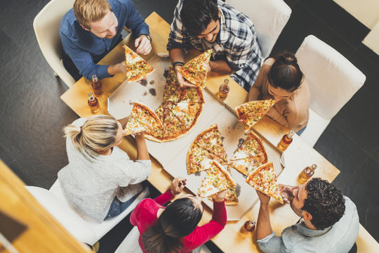 Young people eating pizza and drinking cider