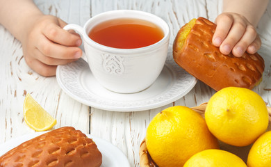 Breakfast child tea and fresh homemade cakes with lemon filling. Rustic style. Selective focus