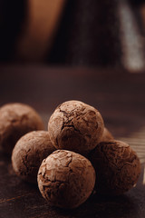 Chocolate truffles with cocoa powder on wooden background