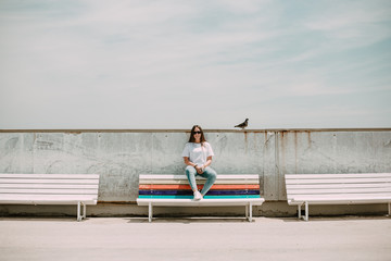 Beautiful woman on the beach with a mobile and a bird